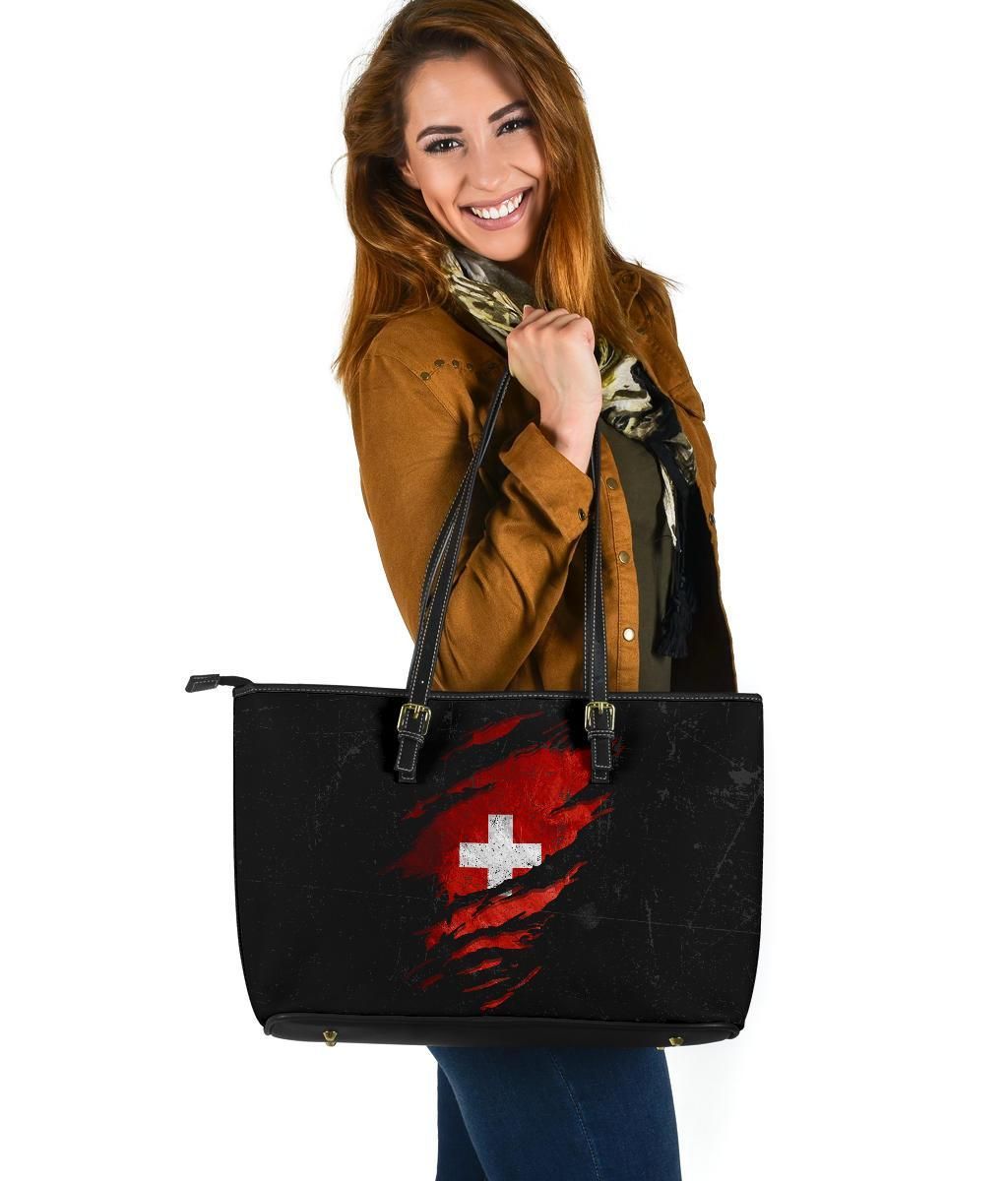 Black leather tote with red distressed Swiss cross graphic, zip-top and double handles