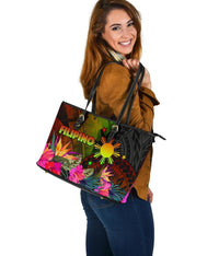 Side view of colorful tote bag with top zipper and tropical hibiscus/leaf print, black straps