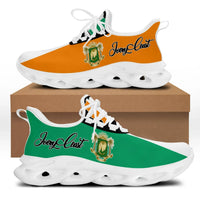 Clunky sneakers with orange and green upper, white laces, and white ridged sole