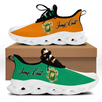 Clunky sneakers with black upper, orange and green accents, and white ridged sole