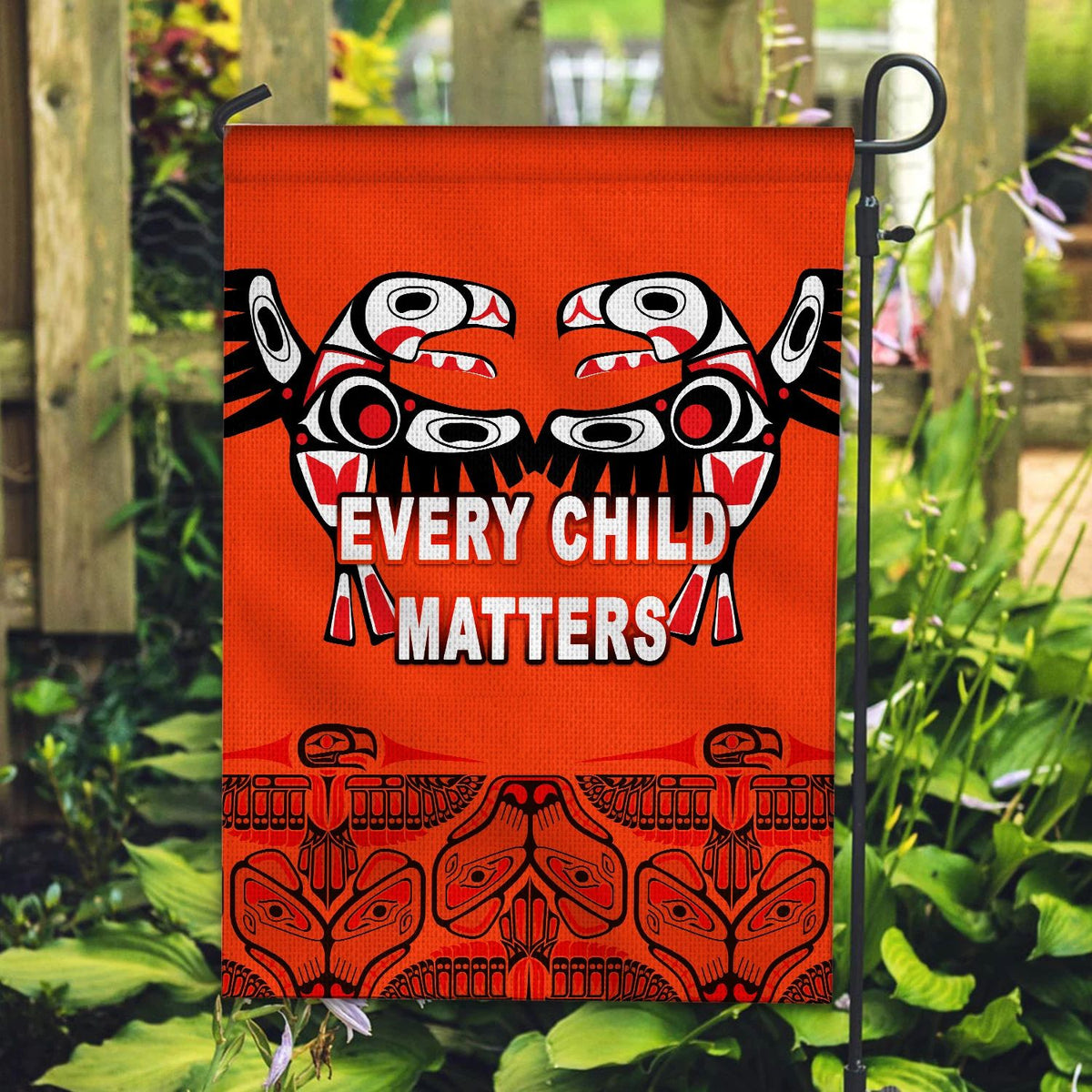Orange house flag with totem bird artwork and “Every Child Matters” text