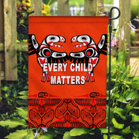 Orange house flag with totem bird artwork and “Every Child Matters” text