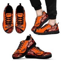 Orange sneakers, black sole, 'EVERY CHILD MATTERS' print on sides