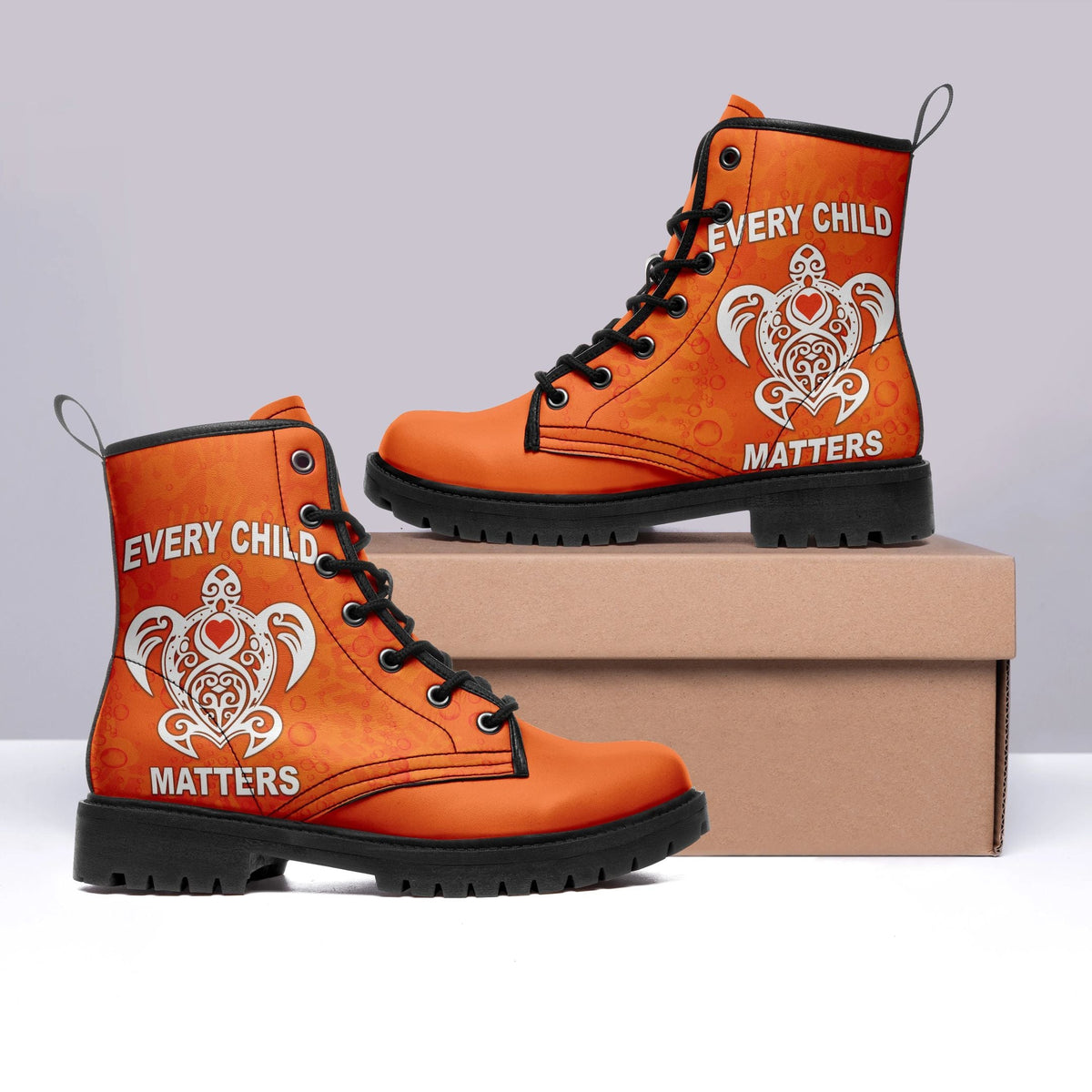 Orange high-top leather boots with black laces and white “Every Child Matters” heart graphic