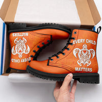Orange high-top boots in box, black laces, “Every Child Matters” heart and flourish print