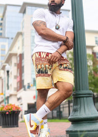 Men's yellow N.W.A graphic shorts worn with white T-shirt, drawstring waistband
