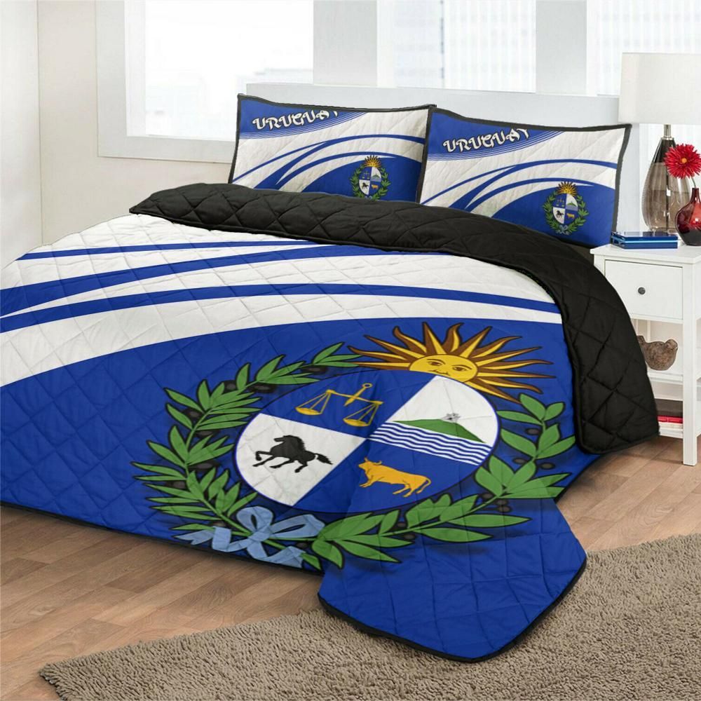 Blue quilt bed set on bed with Uruguay crest, two matching pillow shams