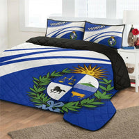 Blue quilt bed set on bed with Uruguay crest, two matching pillow shams