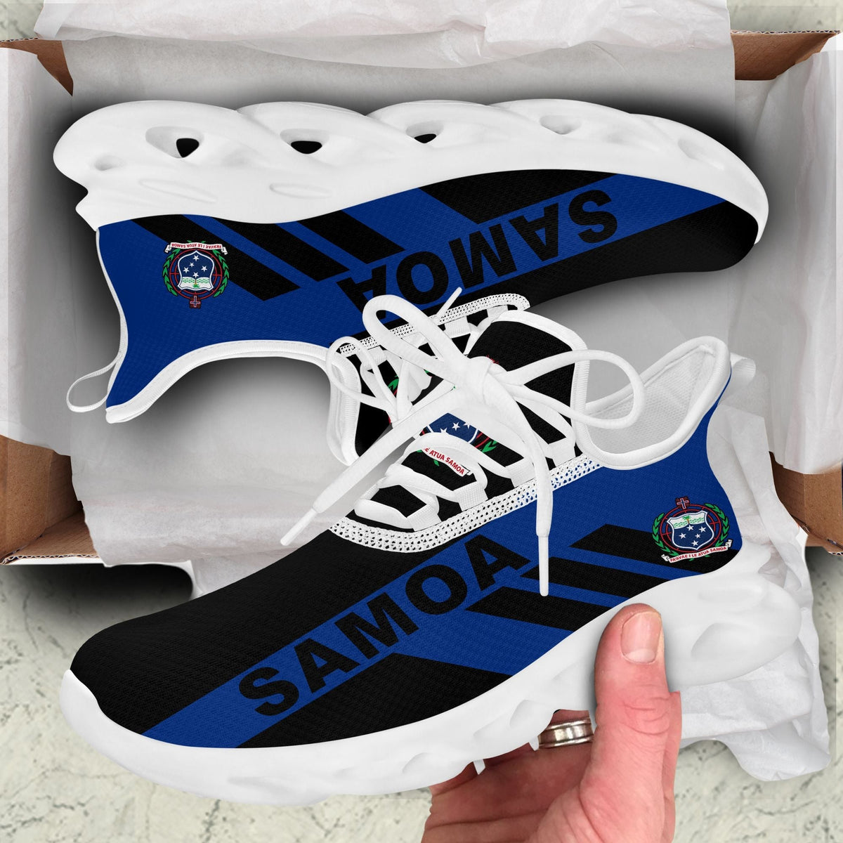 White clunky sneakers with blue SAMOA stripe and white ridged sole in box