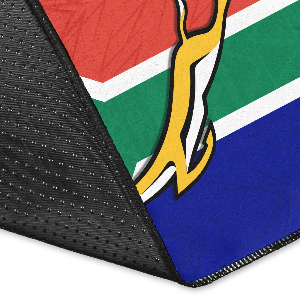 Springboks area rug corner close-up with black edge binding and tri-color print