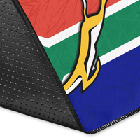 Springboks area rug corner close-up with black edge binding and tri-color print