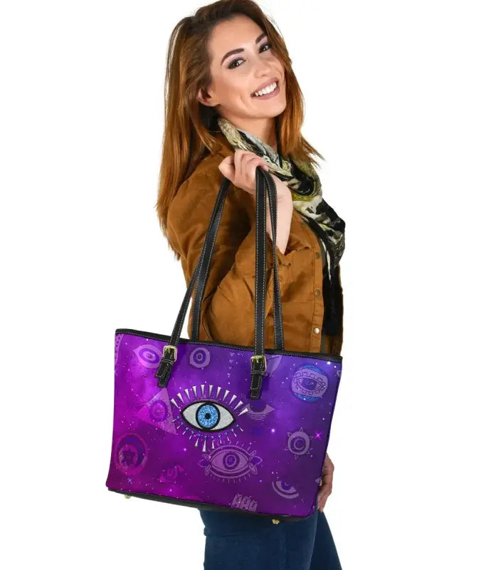 Purple small leather tote with evil eye graphic, black top handles and zipper pull