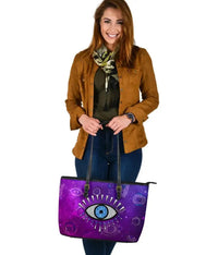 Large purple leather tote with evil eye design and black handles, front view
