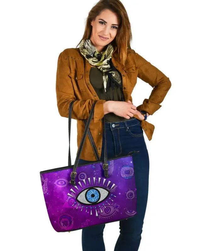 Purple leather tote with centered evil eye motif, black straps and sturdy bottom
