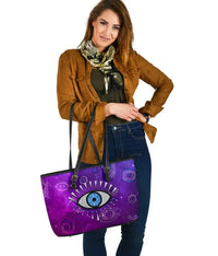 Purple leather tote with centered evil eye motif, black straps and sturdy bottom