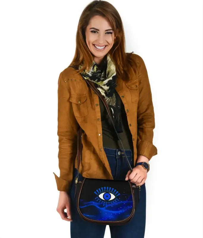 Blue evil eye leather saddle bag with adjustable strap and front flap detail
