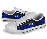White low top sneakers with blue galaxy evil eye graphic and black stripe detail.