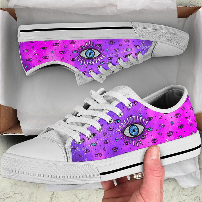 Pink and purple low-top sneakers with evil eye graphic, white laces and white sole