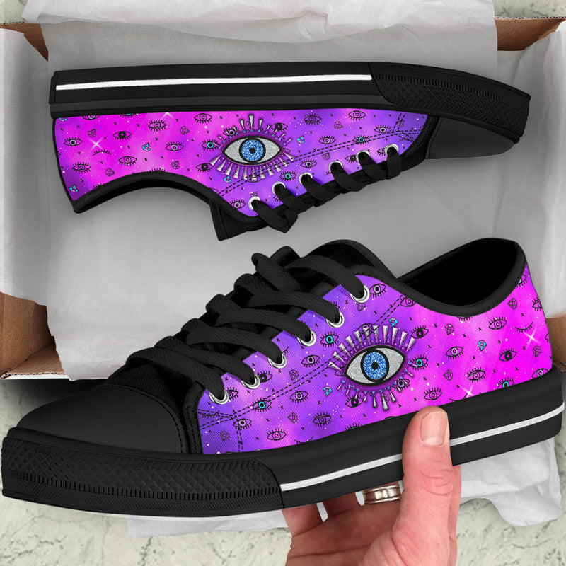 Pink and purple low-top sneakers with evil eye print, black laces and black rubber sole