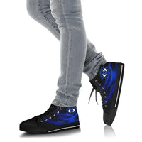 Black high-top sneakers with blue evil eye graphic, worn with gray jeans, black laces
