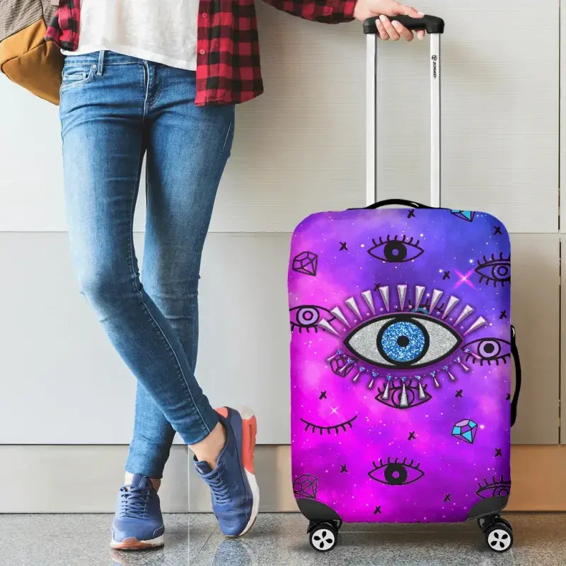 Pink suitcase cover with large evil eye design on front panel, handle cutout