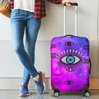 Pink suitcase cover with large evil eye design on front panel, handle cutout