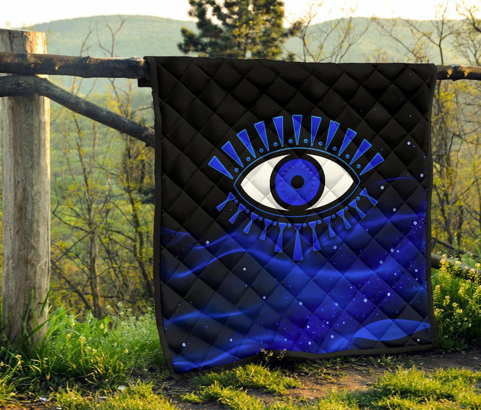 Outdoor view of blue-and-black evil eye premium quilt with diamond stitch pattern