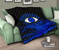 Blue evil eye quilt over a sofa arm, black quilted section with large blue eye