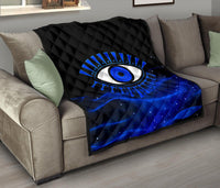 Blue quilt with black diamond quilting and large evil eye motif in blue and white