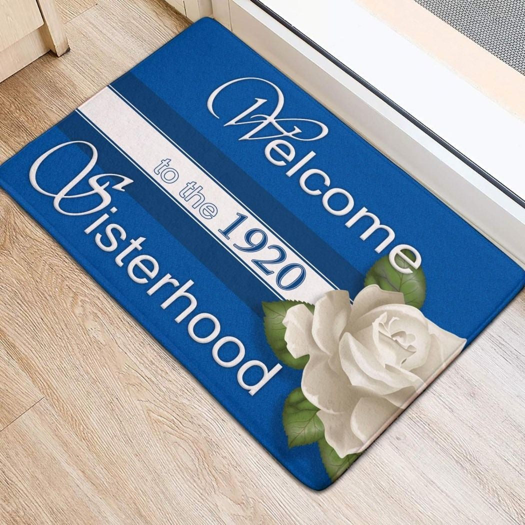 Blue welcome door mat: 'Welcome to the 1920' and 'Be cheerful' with flowers