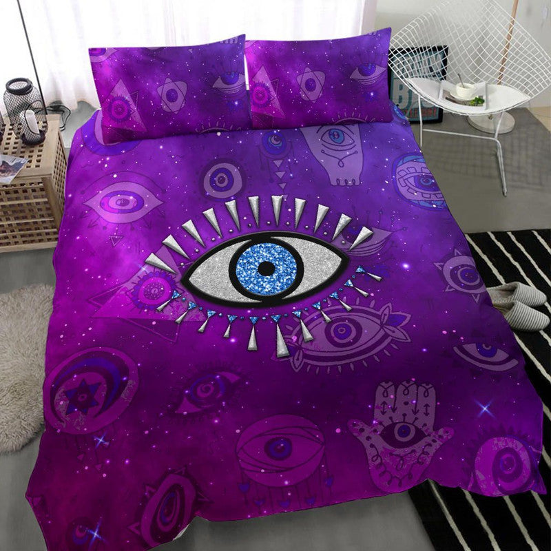 Purple duvet cover and pillows with blue evil eye centerpiece and galaxy symbols