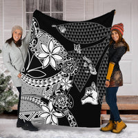 Black Hawaiian blanket with white geometric triangles, floral, and tiki motifs