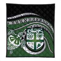 Square green quilt with black backing and circular turtle crest pattern