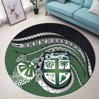 Green round rug with central shield motif: palm, bird, shell, turtle in white/black