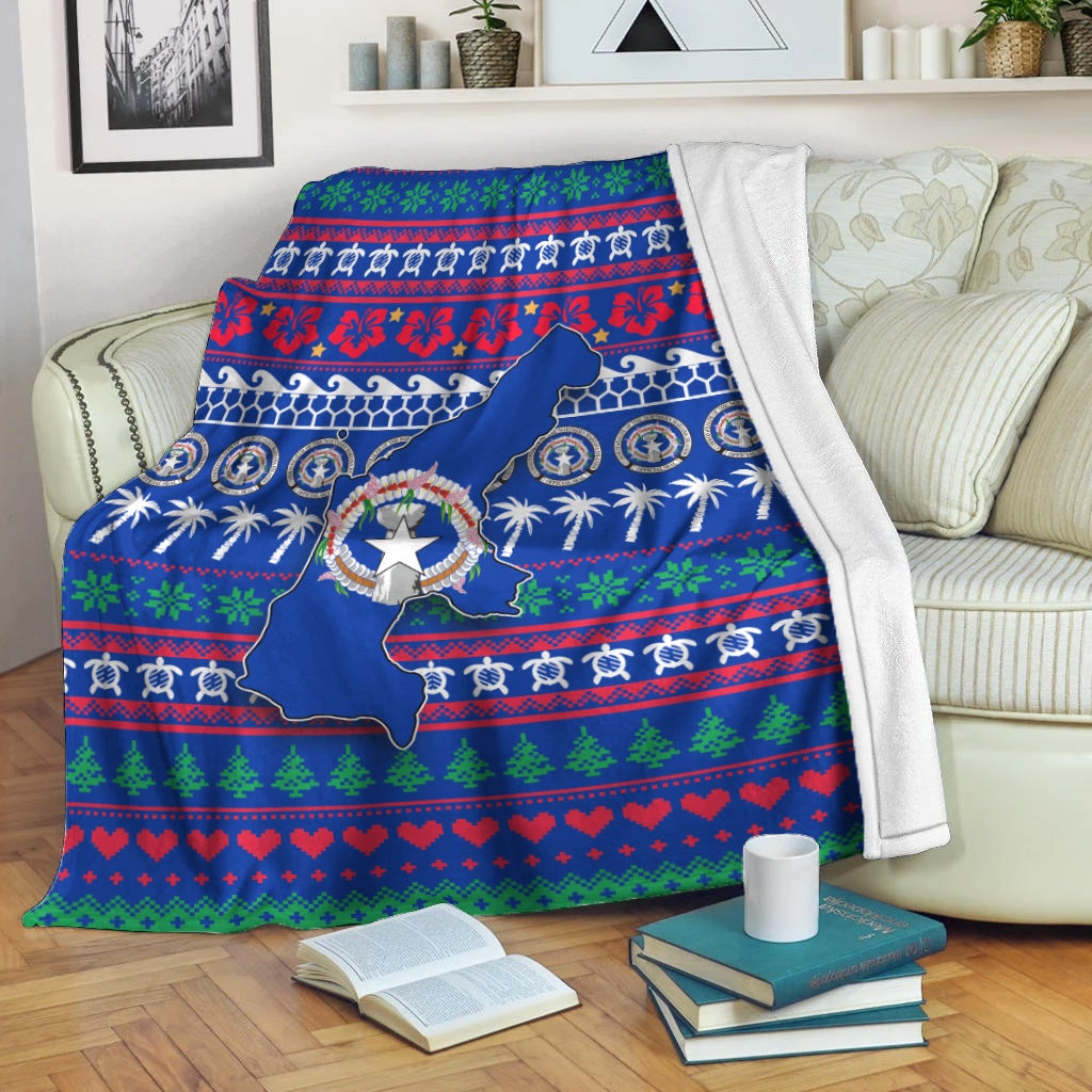 Blue Christmas blanket with North Mariana Islands map, wreath emblem, hearts and trees border