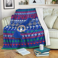 Blue Christmas blanket with North Mariana Islands map, wreath emblem, hearts and trees border