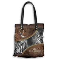 Brown leather tote with black handles, wolf graphic and 'Hello Darkness' text, gold trim
