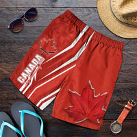 Red men swim shorts with Canada stripes, maple leaf graphic, elastic waistband.