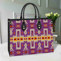 Purple native geometric leather tote with black top handles, gold studs, multicolor trim