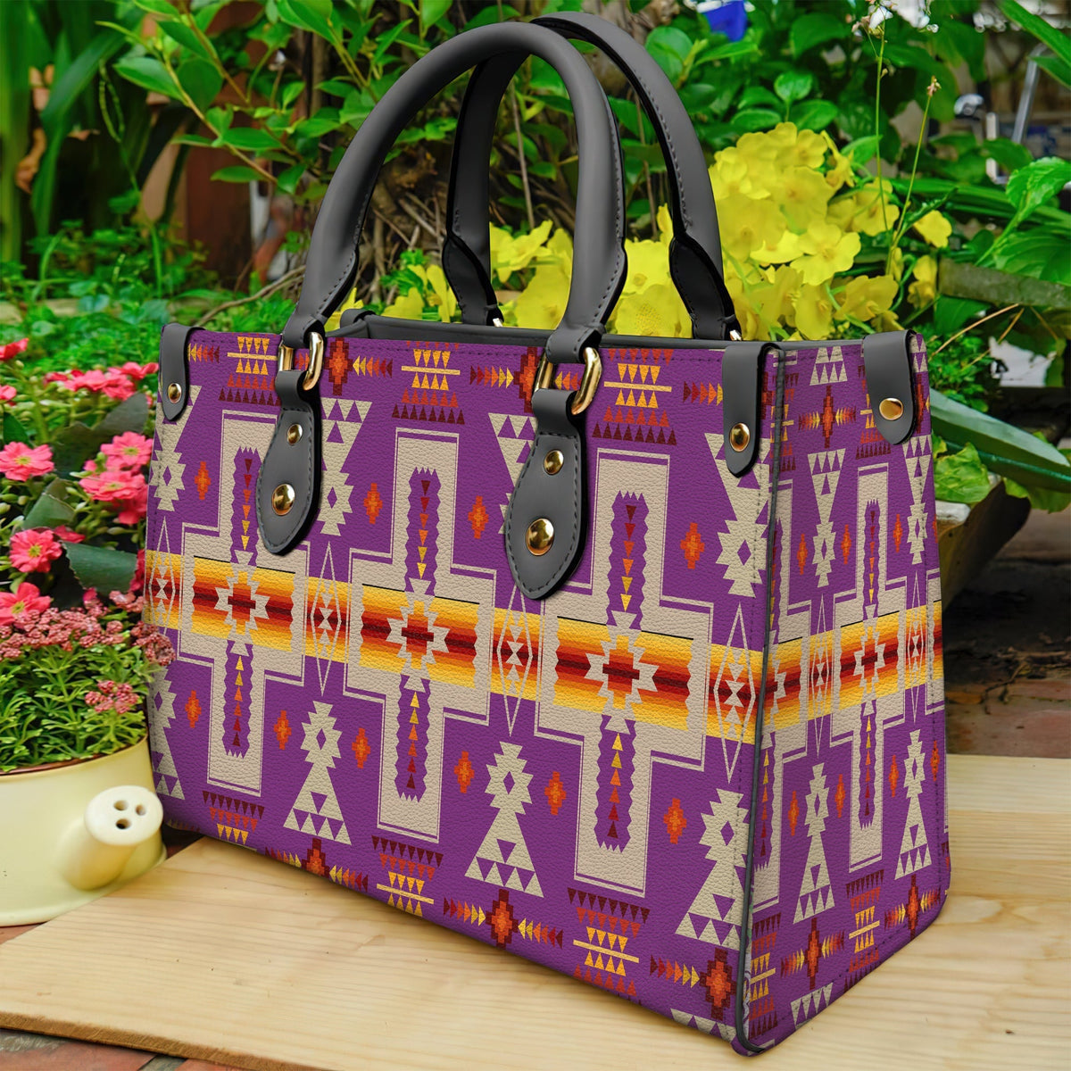 Light purple patterned leather handbag with black handles and native geometric print
