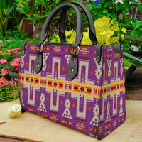 Light purple patterned leather handbag with black handles and native geometric print