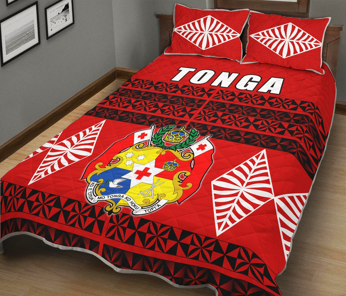 Red Tonga quilt bed set with geometric black pattern, white shell motifs, and crested emblem