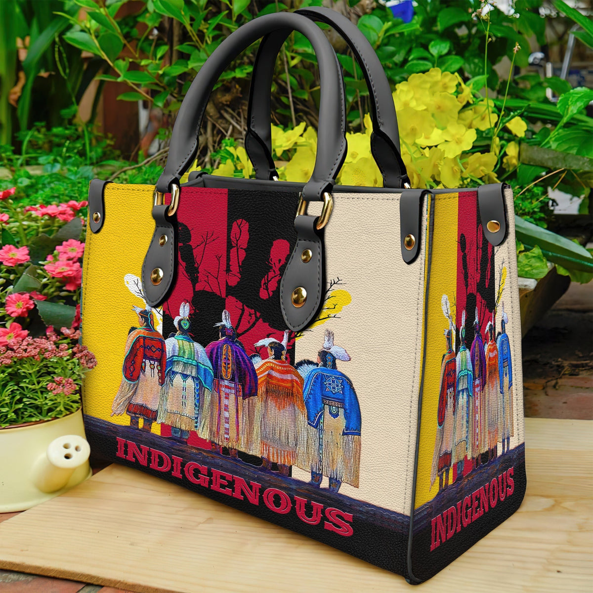 Multicolor leather tote side view with Native-style figures print, studded handles, “INDIGENOUS”