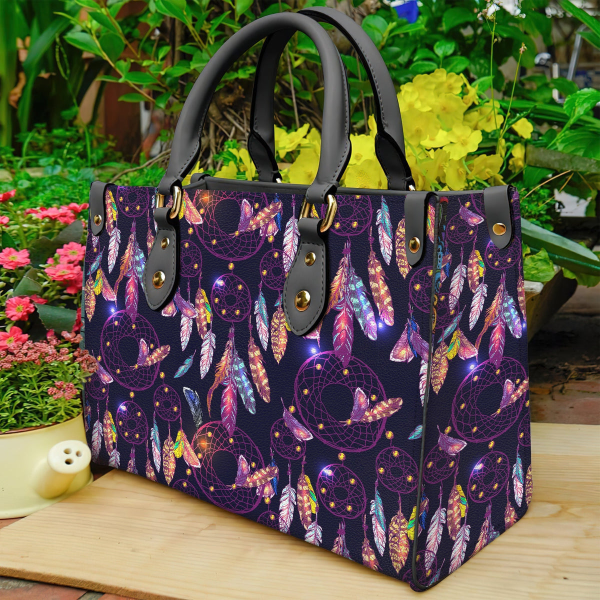 Purple dreamcatcher leather tote with black handles, gold studs, colorful feather print