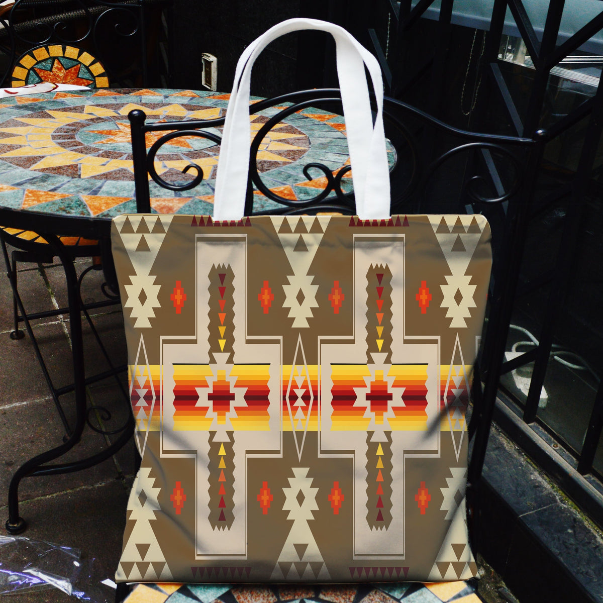 Light brown tribal pattern canvas tote bag with white handles and front design