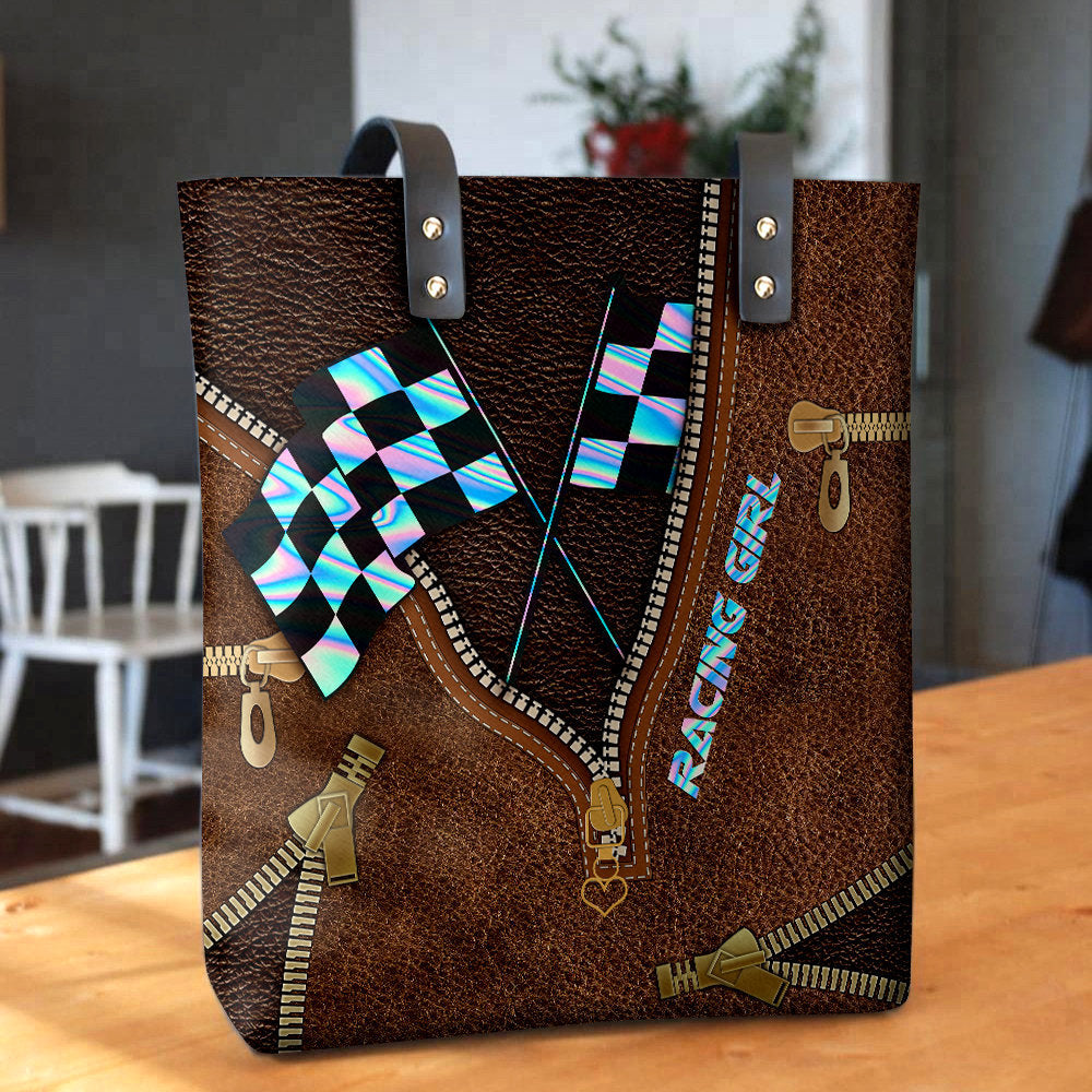 Leather hand bag with top handles, dark strap tabs, and checkered racing flag print.