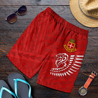 Red men’s athletic shorts with elastic waist and lion wing logo, flat lay