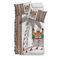 Bedding set in white with brown tapa stripes, coconut leaves, and crest shield art