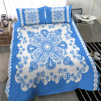 Blue bed set with white medallion swirl pattern, two square pillow shams, and border print
