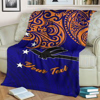 Blue blanket folded on couch, orange tribal swirls, white stars, black bird, “Your Text”